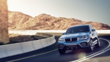 Кроссовер BMW X4 выходит из крутого поворота на шоссе